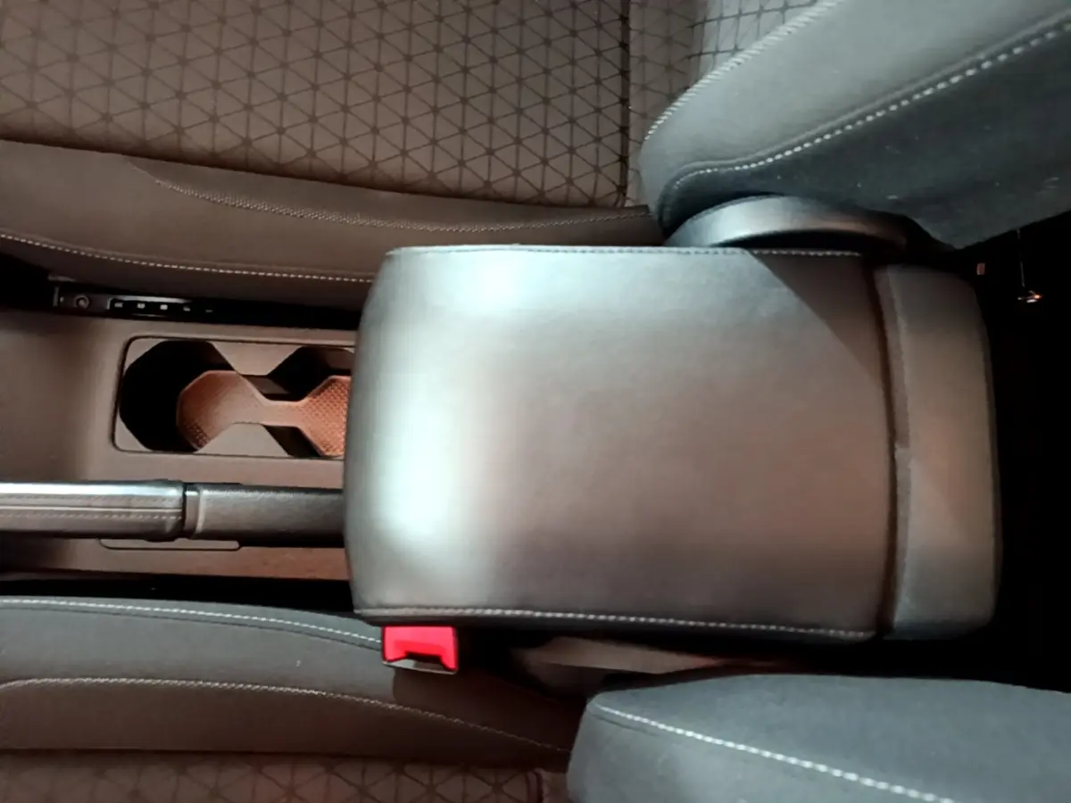 Vue intérieure rapprochée du coffre central en cuir noir entre les sièges avant du Volkswagen T-Cross gris foncé.