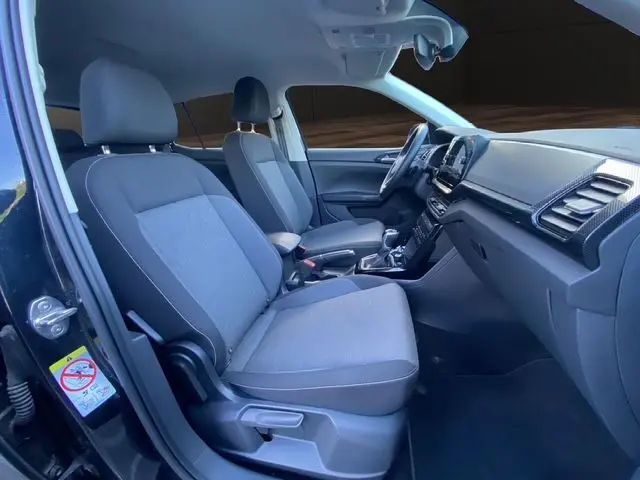 Vue intérieure côté gauche du Volkswagen T-Cross noir 2025, montrant sièges tissu Life et tableau de bord moderne.