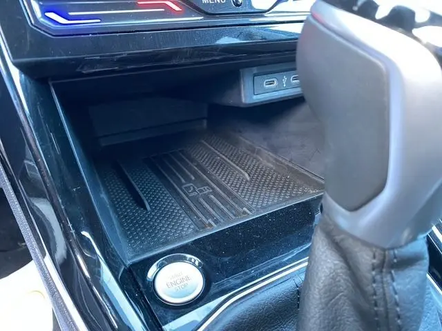 Gros plan sur la console centrale noire du Volkswagen T-Cross 2025, avec bouton start/stop et ports USB-C visibles.