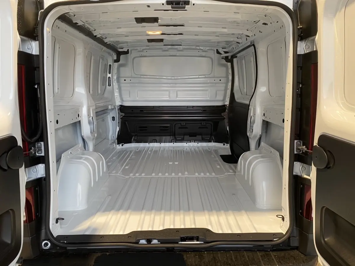 Vue arrière du Renault Trafic Fourgon blanc montrant l’espace de chargement vide et la cloison pleine intérieure.