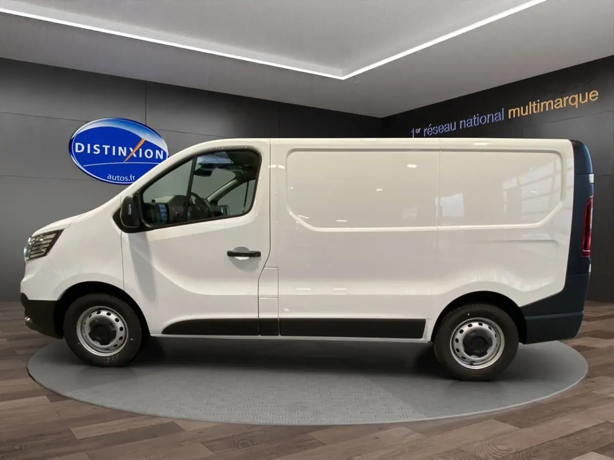 Vue de profil côté gauche du Renault Trafic Fourgon blanc, avec jantes acier et protections noires sur le bas de caisse.