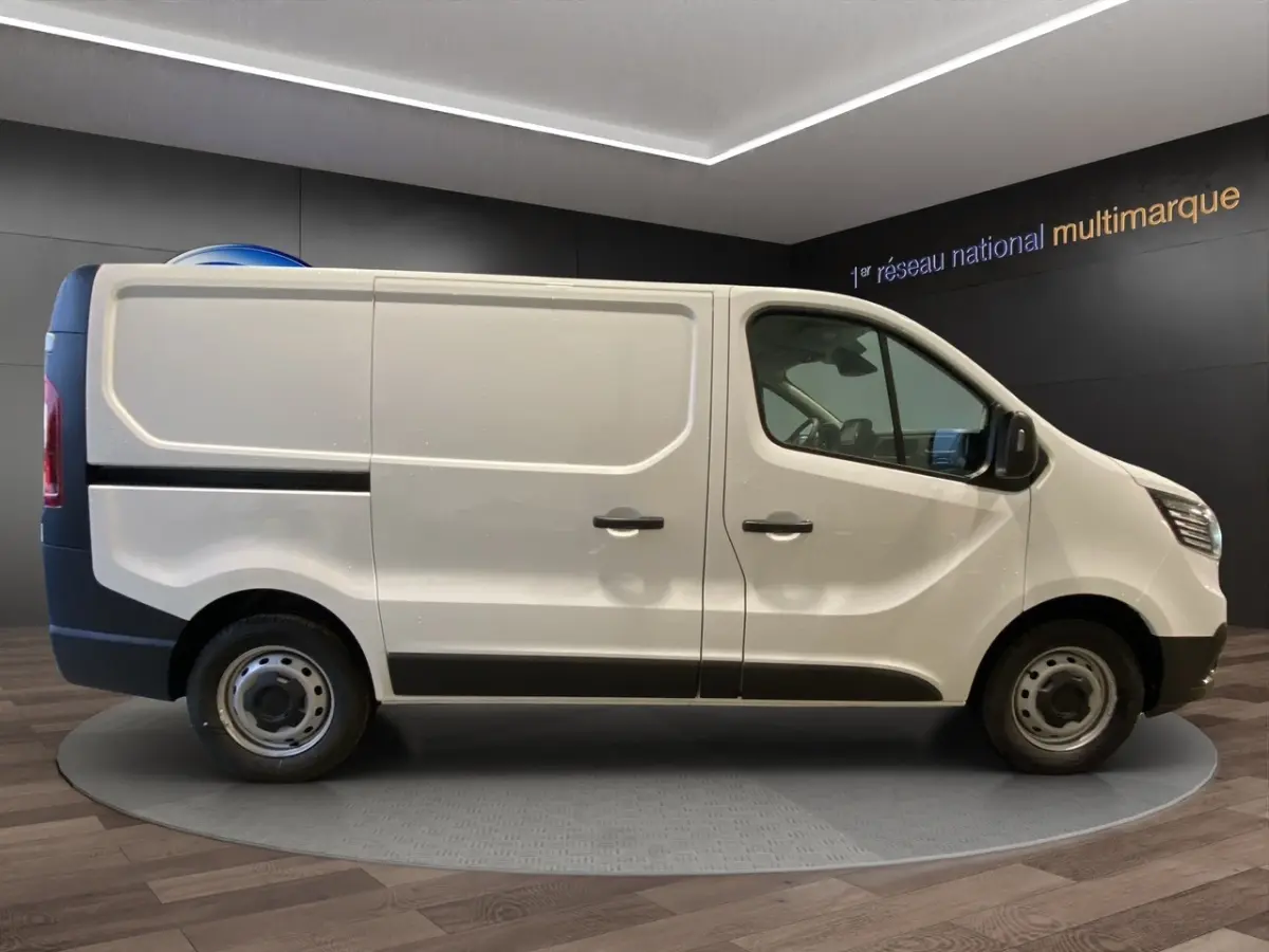 Vue de profil côté gauche du Renault Trafic Fourgon blanc, avec portes latérales pleines et jantes acier simples.