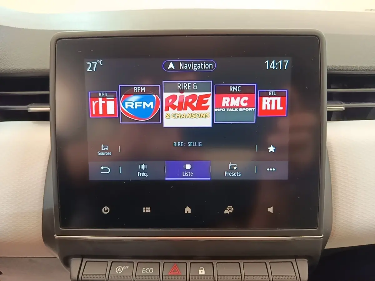 Écran tactile central de la Renault Clio blanche 2023 affichant les stations radio avec interface moderne.