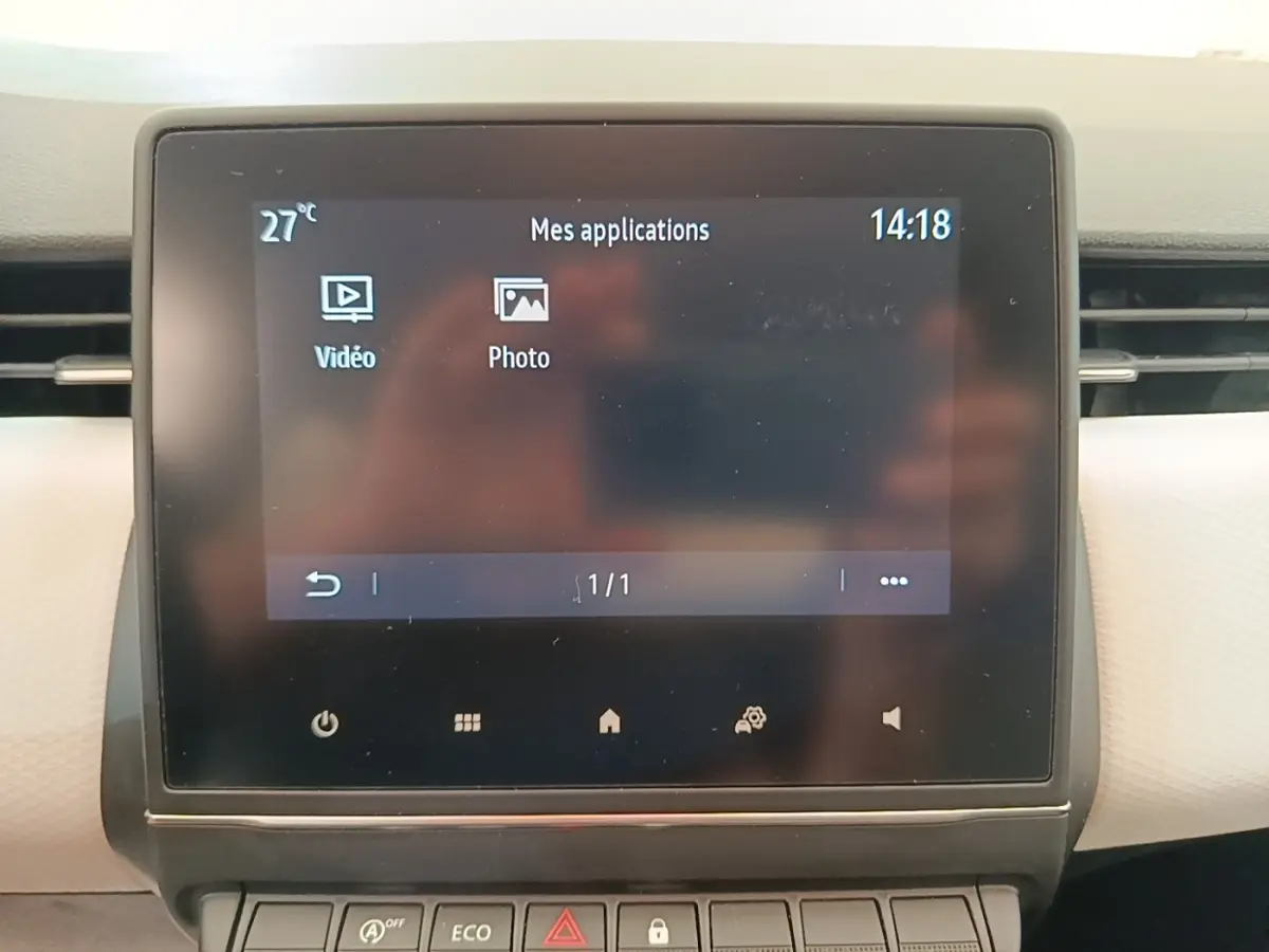 Écran tactile central de la Renault Clio blanc 2023 affichant les applications vidéo et photo.