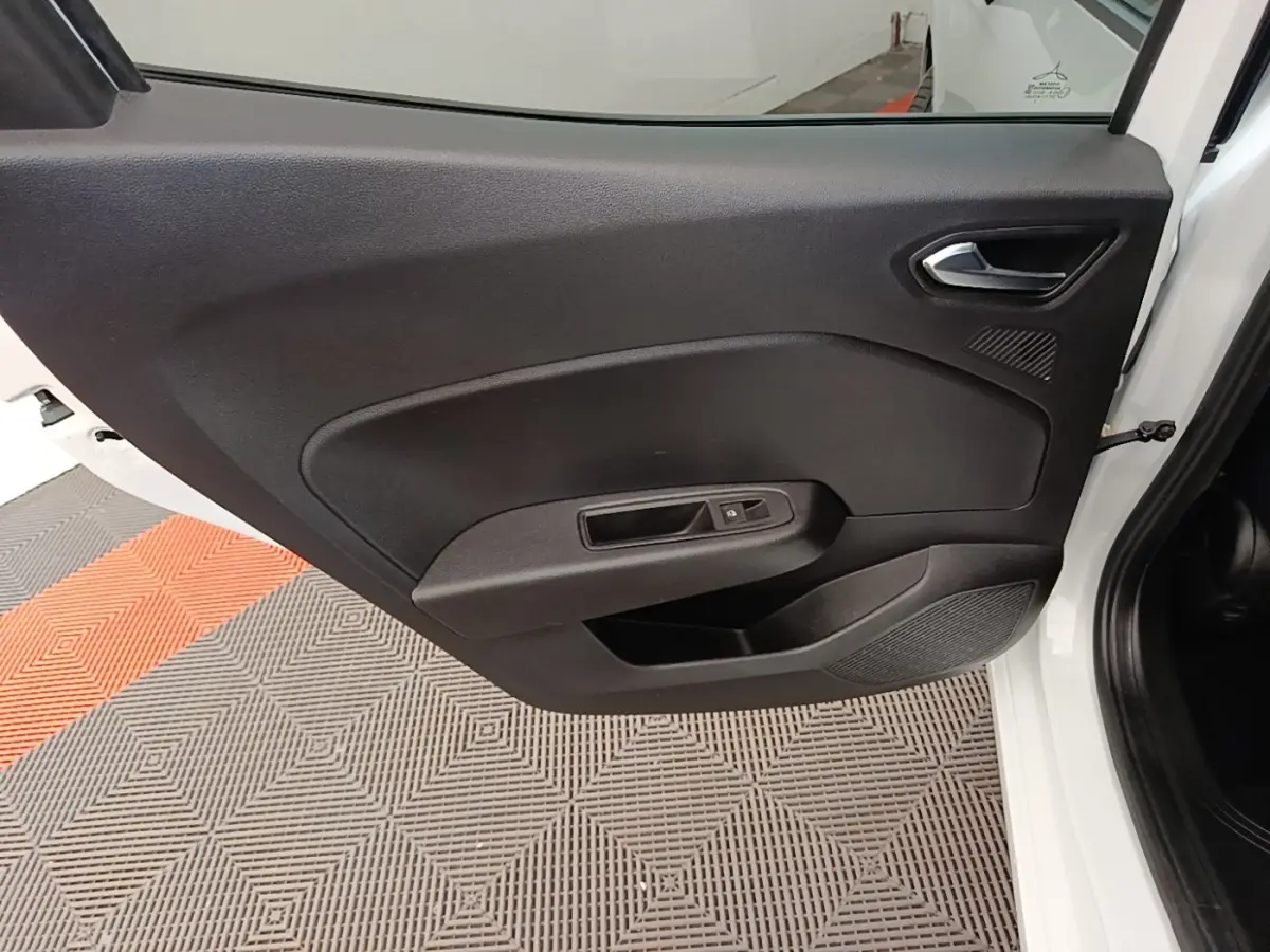 Vue intérieure de la porte avant gauche d'une Renault Clio blanche, avec panneau noir et commande de vitre électrique.
