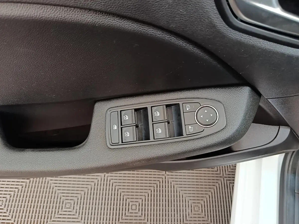 Commande des vitres électriques et réglages des rétroviseurs sur la porte côté conducteur d'une Renault Clio blanche 2023.