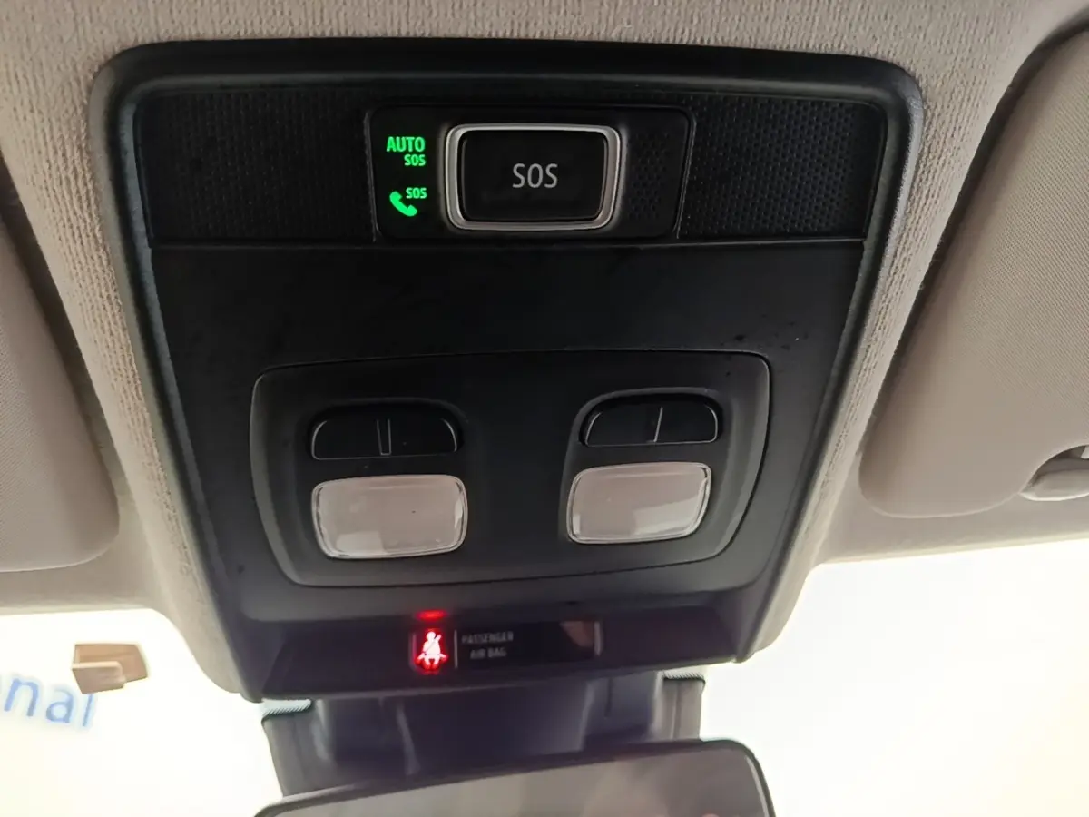 Vue intérieure du plafonnier avec bouton SOS éclairé et commandes d'éclairage dans une Renault Clio blanche 2023.