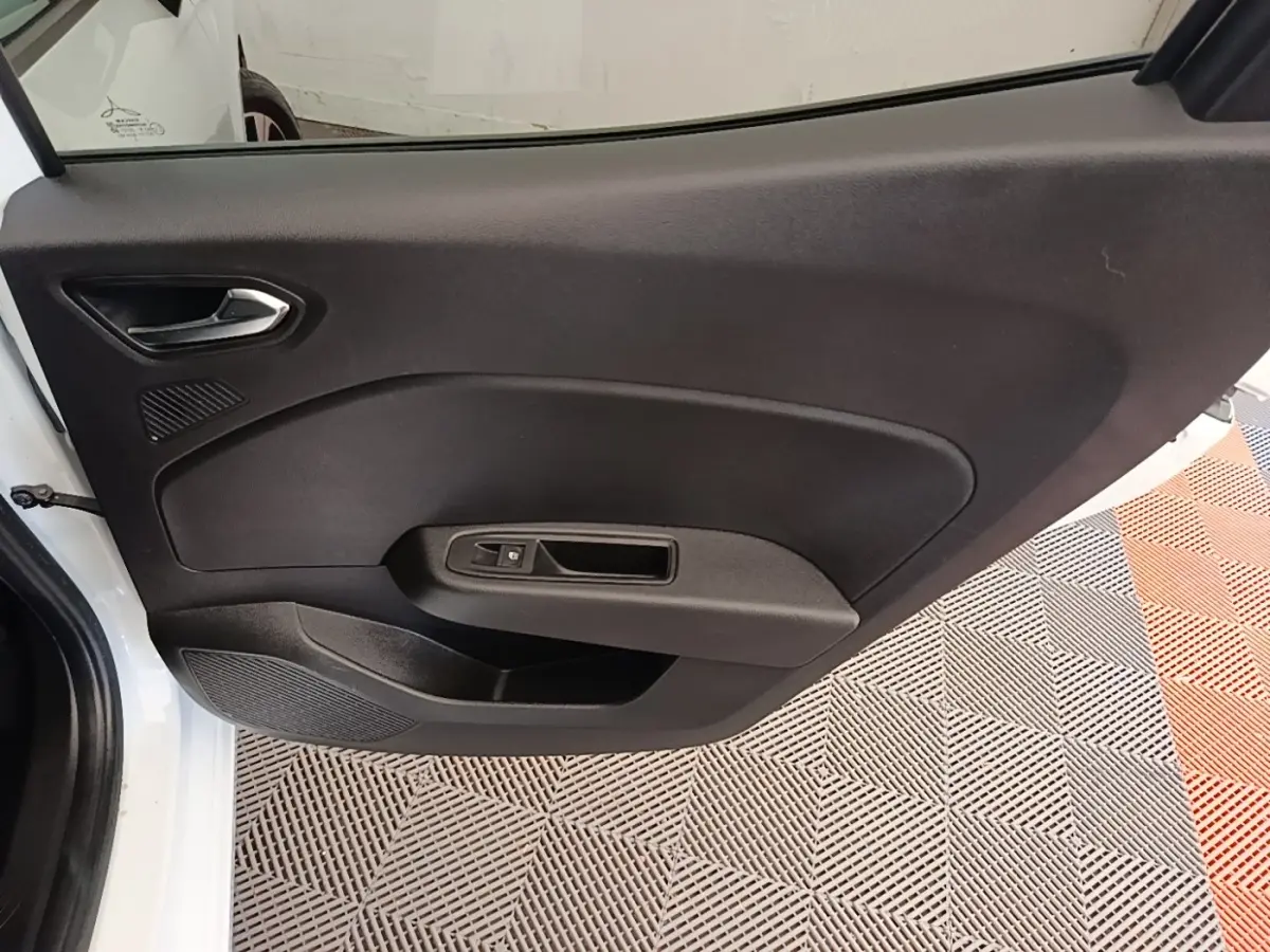 Vue intérieure de la porte avant gauche noire d'une Renault Clio blanche 2023, avec poignée argentée et commande de vitre.
