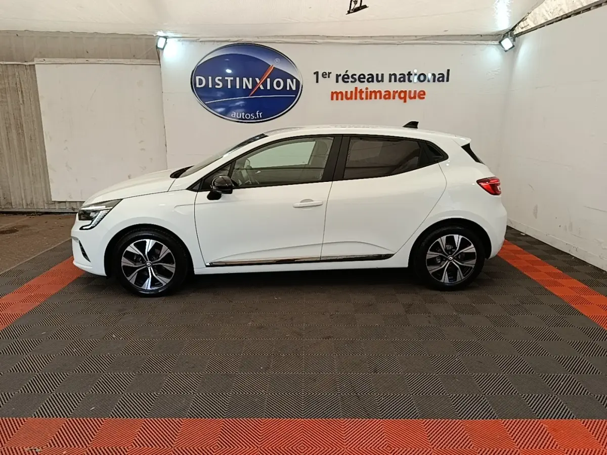 Profil côté gauche d'une Renault Clio blanche 2023 Evolution TCe 90, avec jantes alliage et vitres teintées.
