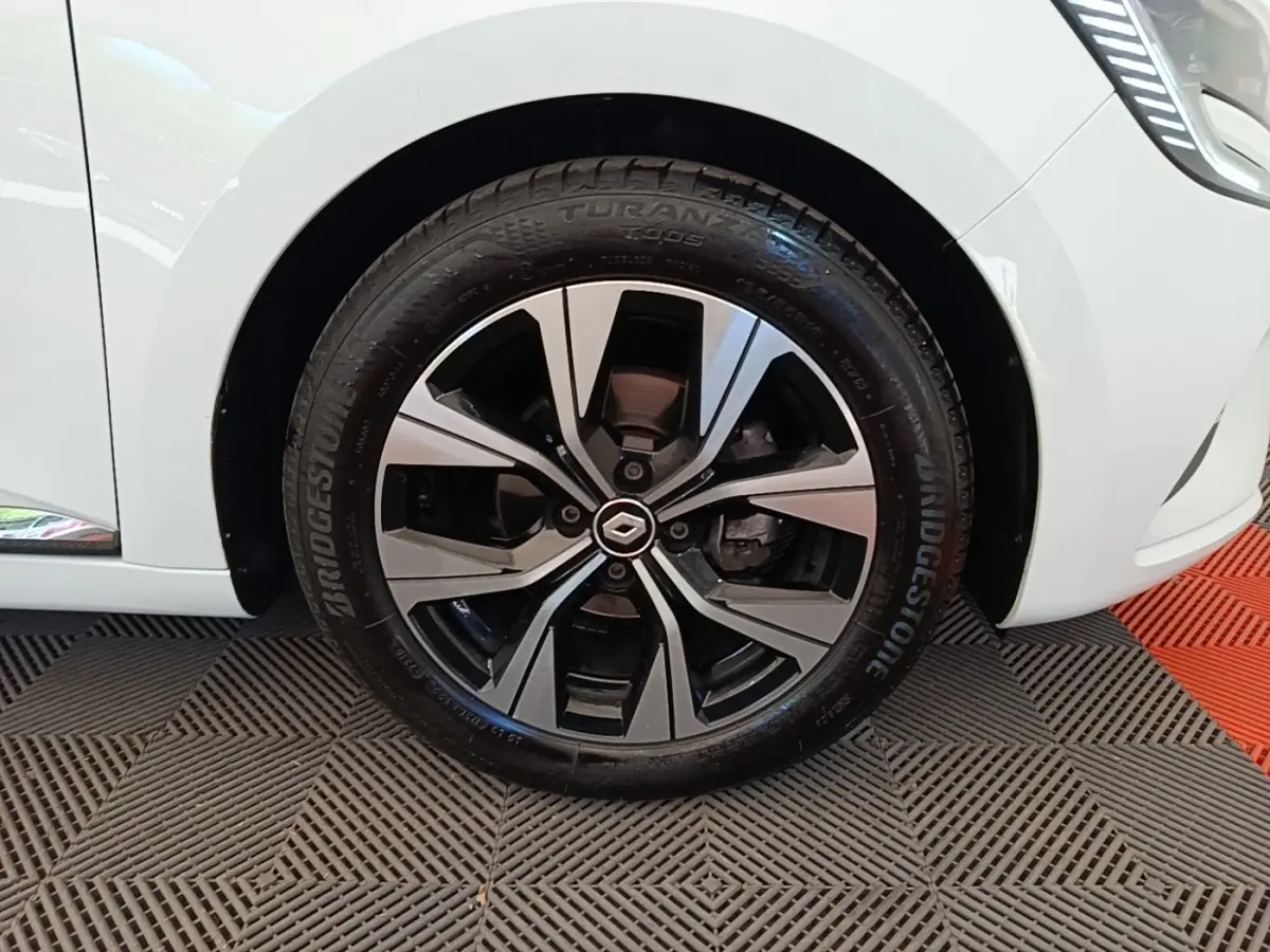 Gros plan sur la roue avant droite de la Renault Clio blanche 2023, avec jante alliage au design moderne.