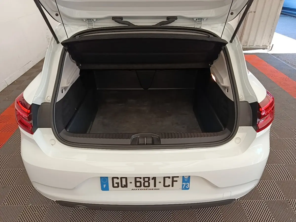 Vue arrière d'une Renault Clio blanche 2023 avec coffre ouvert montrant l'espace de chargement vide.