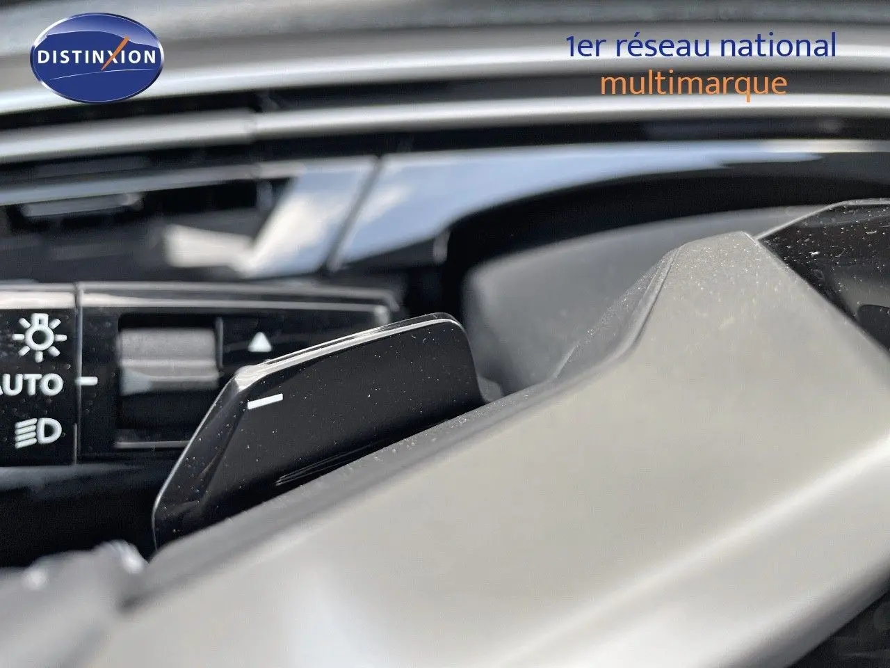 Gros plan sur la palette de changement de vitesse et les commandes d'éclairage du tableau de bord d'un Peugeot 3008 hybride.