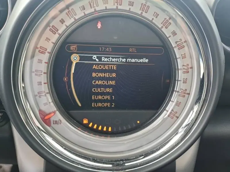 Affichage central du tableau de bord du MINI Countryman Cooper D 2014, avec écran de recherche radio et cadran circulaire chrome.