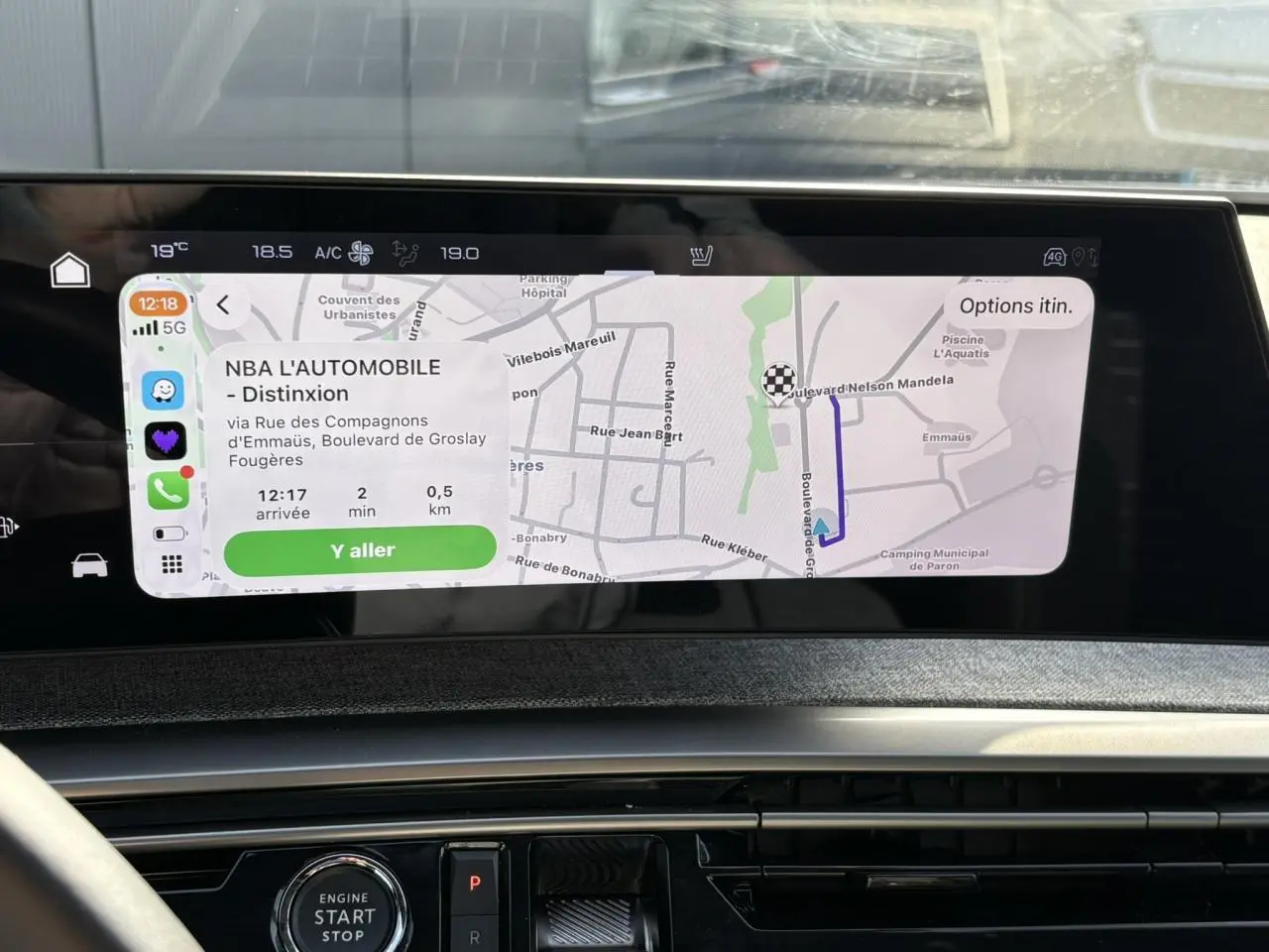 Vue rapprochée de l’écran tactile du GPS panoramique 21 pouces du Peugeot 3008 Hybrid blanc Okenite, affichant un itinéraire.