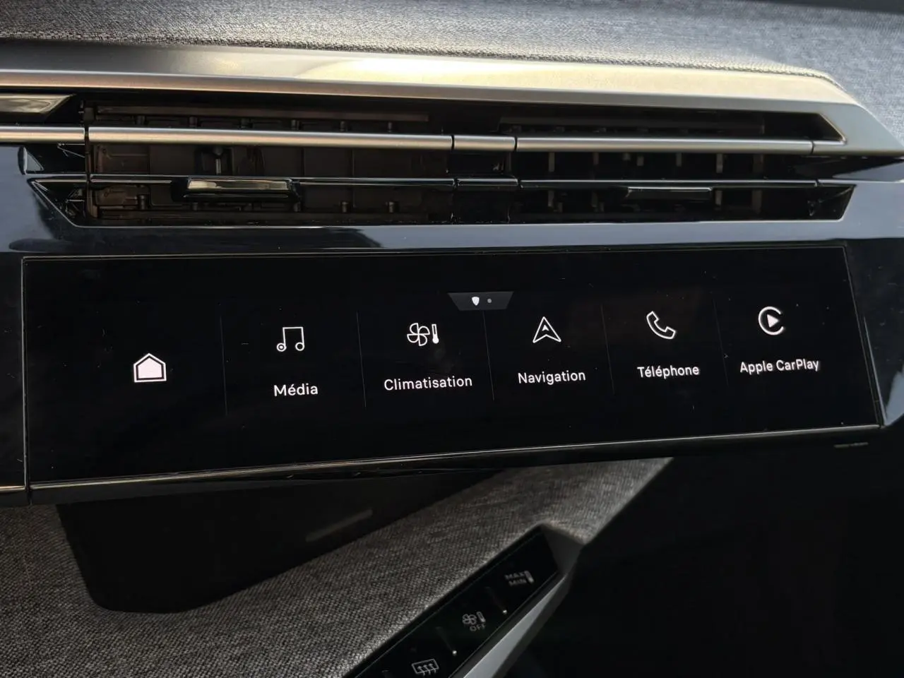 Vue rapprochée de l’écran tactile central noir du Peugeot 3008 Hybrid 2025 avec commandes multimédia et climatisation.