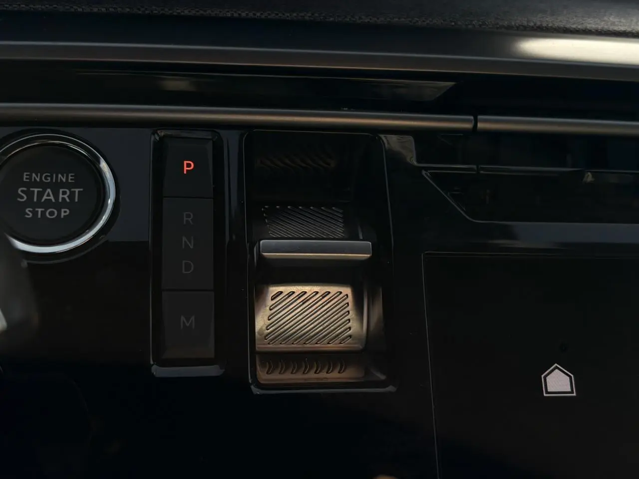 Gros plan sur la console centrale noire du Peugeot 3008 Hybrid avec bouton start/stop et commande de boîte automatique digitale.