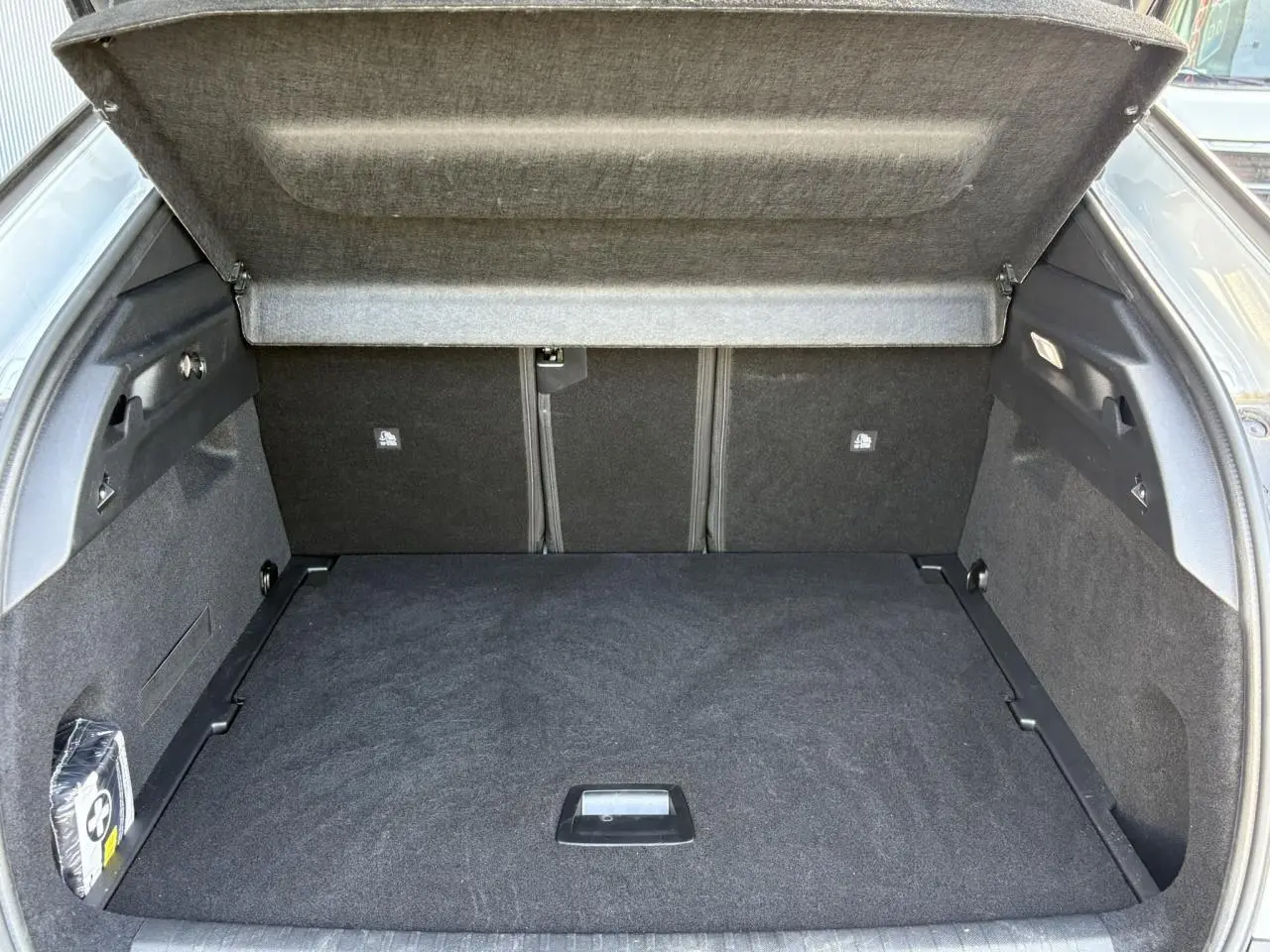 Coffre ouvert vu de l'arrière d'un Peugeot 3008 blanc, montrant un espace de chargement propre et spacieux.