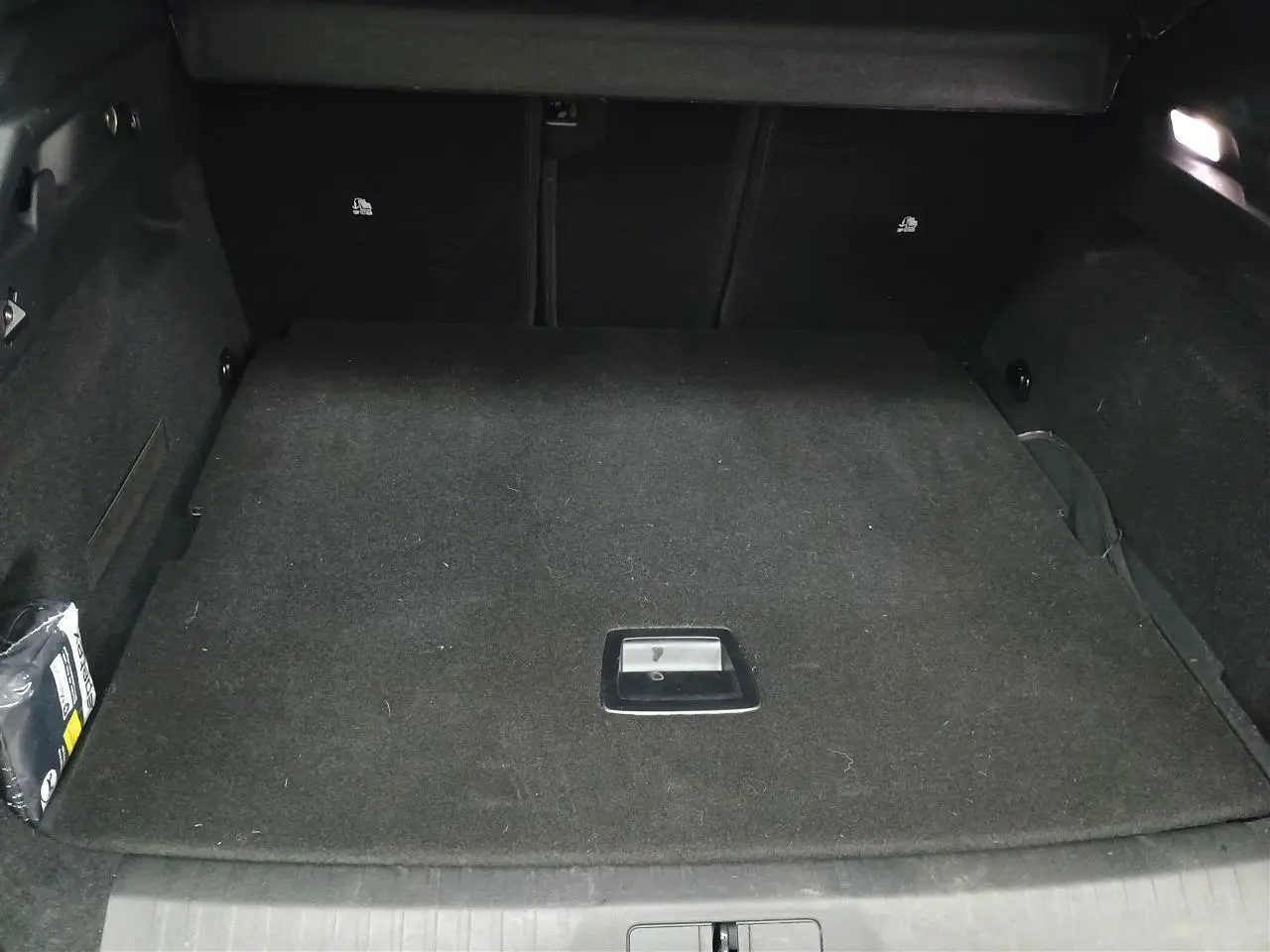 Gros plan sur le volant cuir noir du Peugeot 3008 Hybrid 2025 avec commandes intégrées et logo lion central.