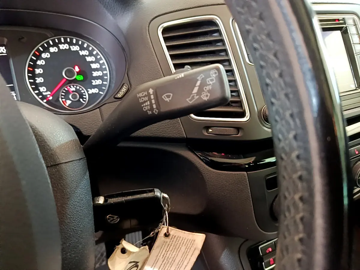 Vue intérieure rapprochée du volant cuir et du combiné d'instruments du Volkswagen Sharan 2017, avec commandes au volant visibles.