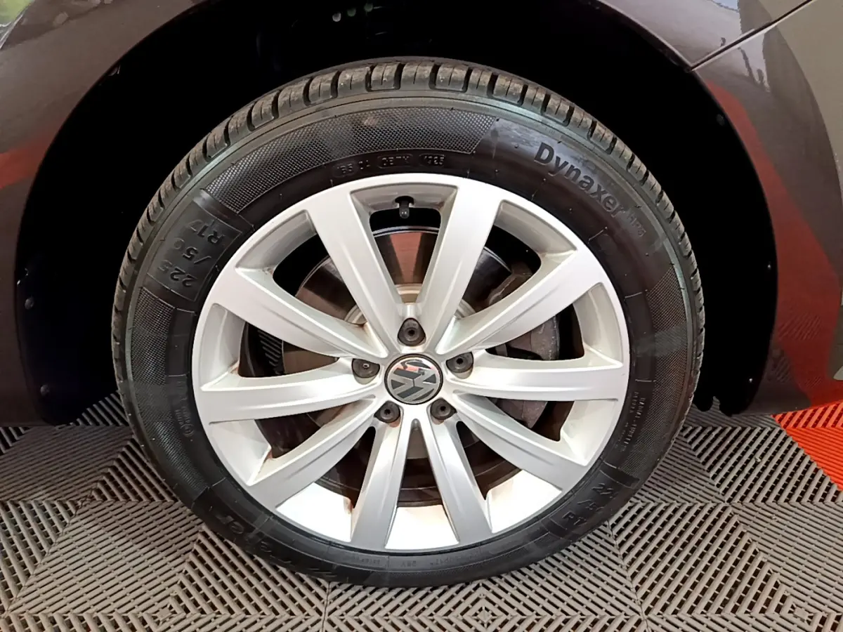 Gros plan sur la roue avant droite avec jante alliage argentée du Volkswagen Sharan marron 2017.