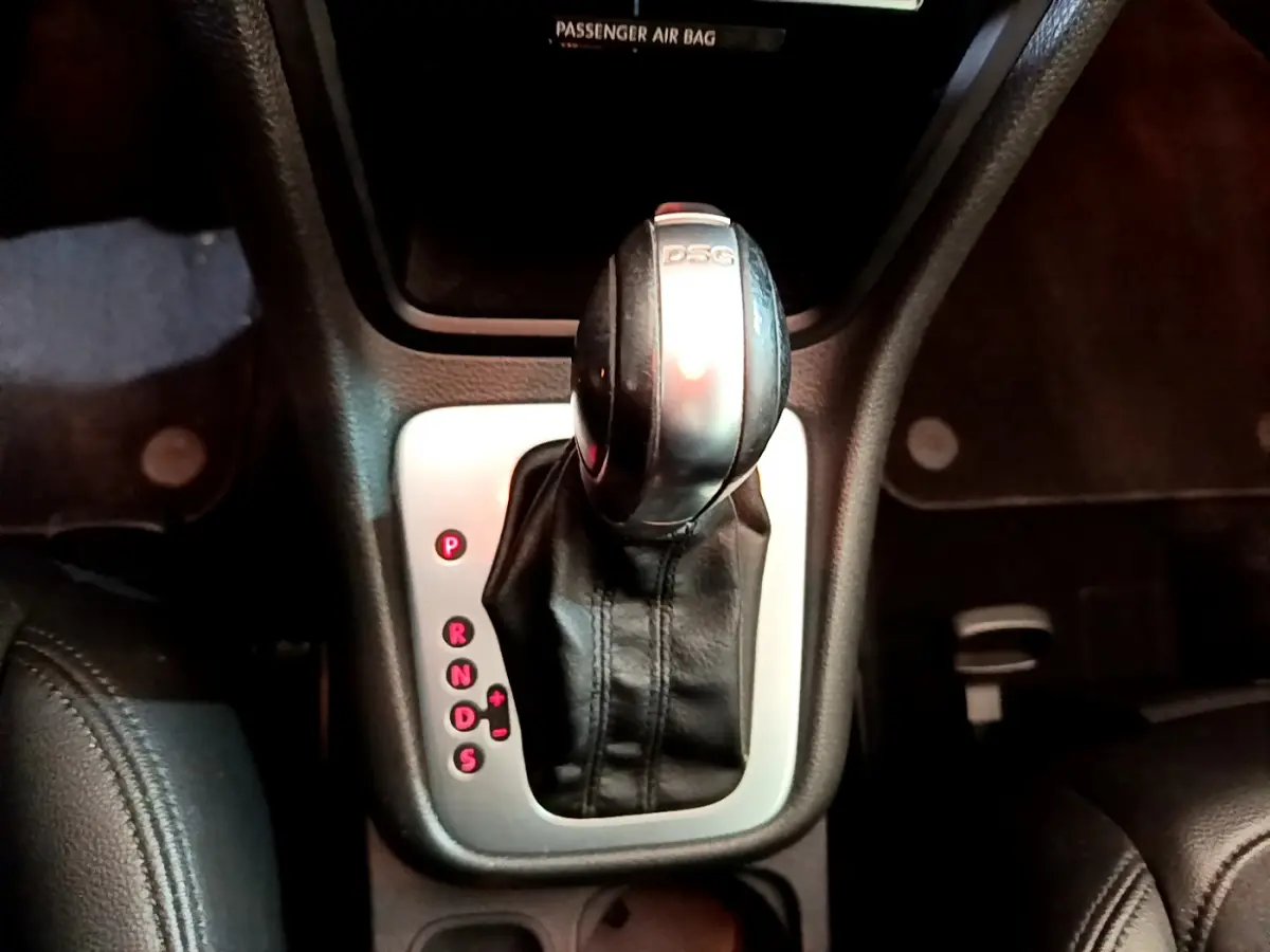 Gros plan sur le levier de vitesses DSG noir et argenté dans l’habitacle du Volkswagen Sharan marron de 2017.