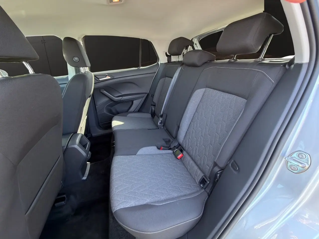 Vue intérieure côté droit sur la banquette arrière tissu gris et noir du Volkswagen T-Cross reflet d'argent 2025.