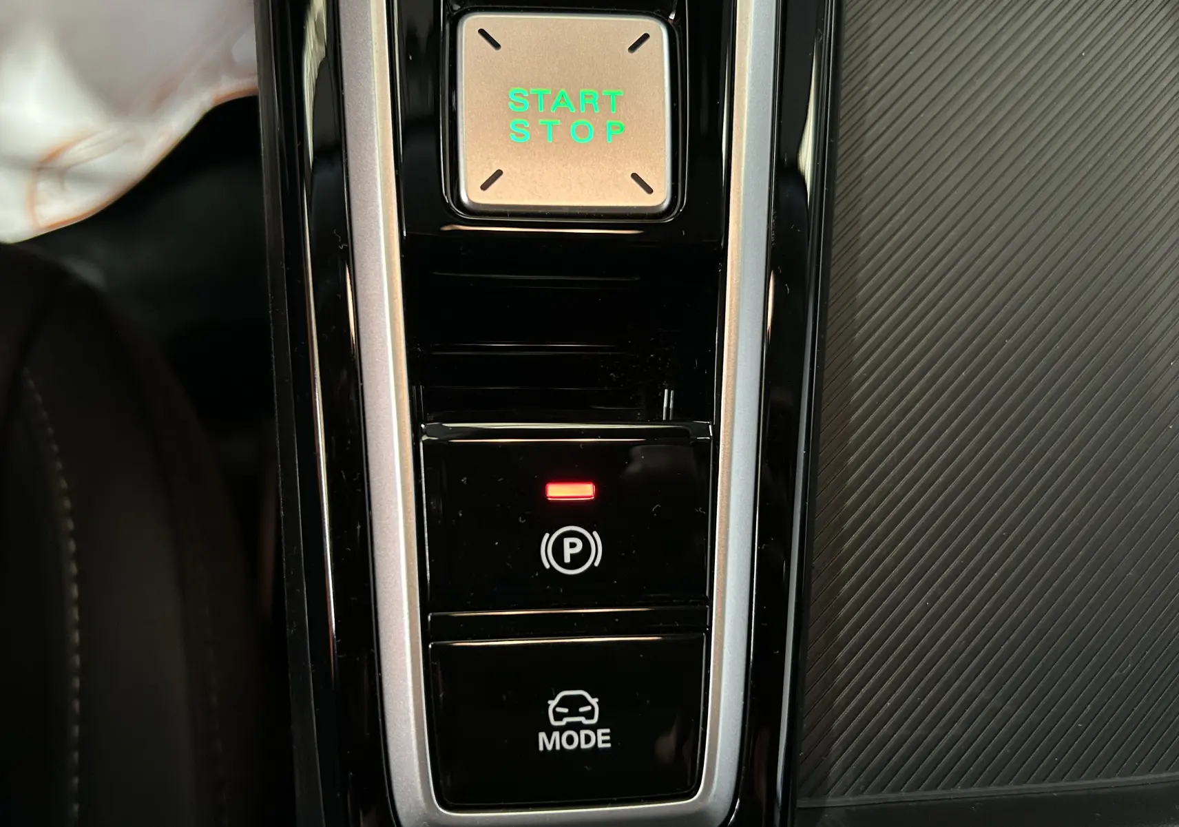 Vue rapprochée de la console centrale du MG ZS Dover White 2026, avec bouton Start/Stop vert et frein à main électronique activé.