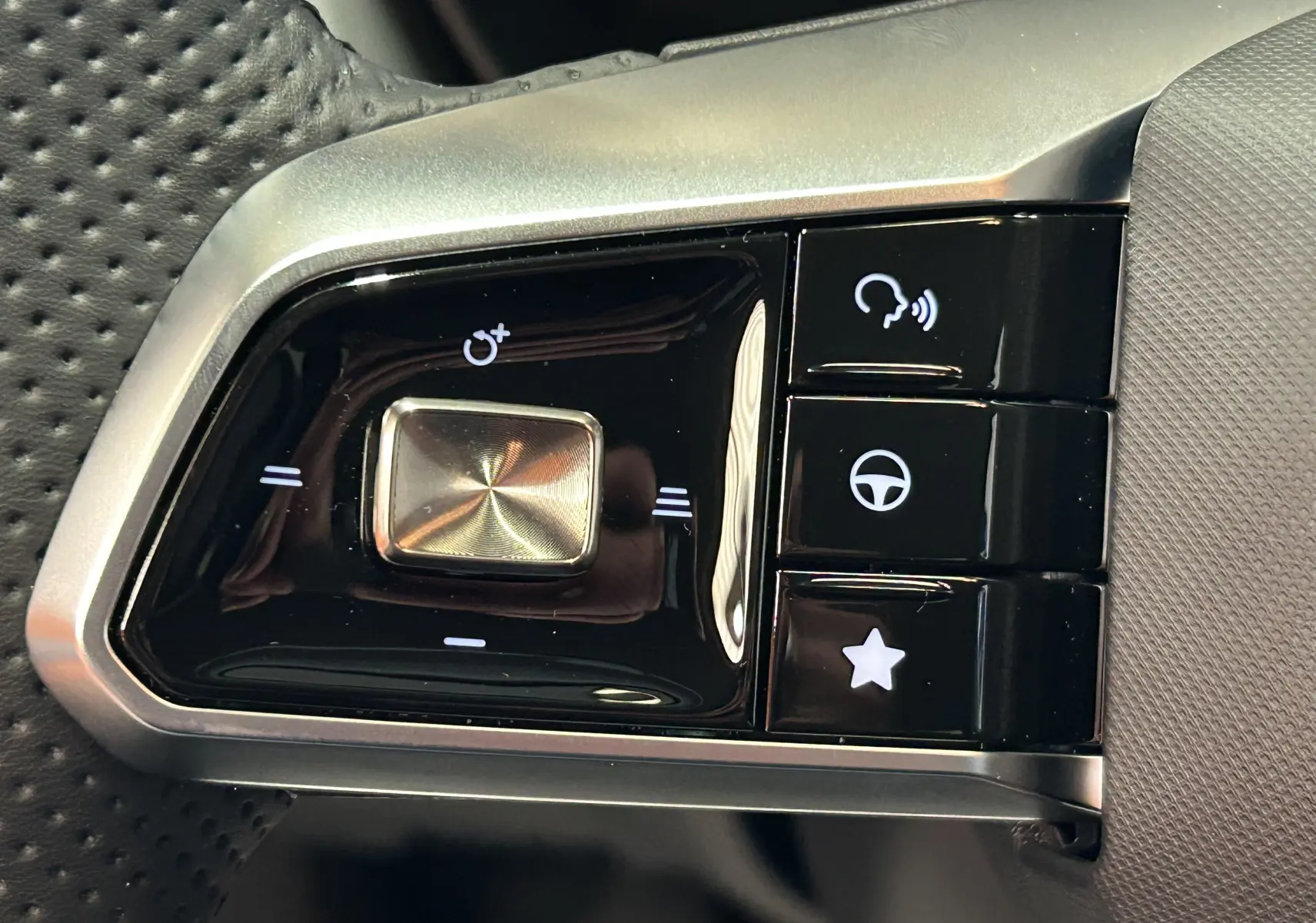 Gros plan sur les commandes au volant noir et argent du MG ZS 1.5 Hybrid+ 197 Luxury, boutons multifonctions rétroéclairés.