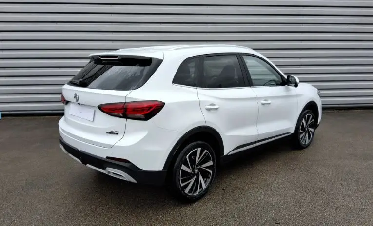 Vue 3/4 arrière droite du SUV MG ZS 1.5 Hybrid+ 197 Luxury en blanc Dover avec jantes alliage bicolores.