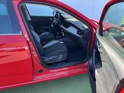 Vue côté gauche intérieur de la Skoda Scala rouge velvet metal 2024, montrant sièges et tableau de bord moderne