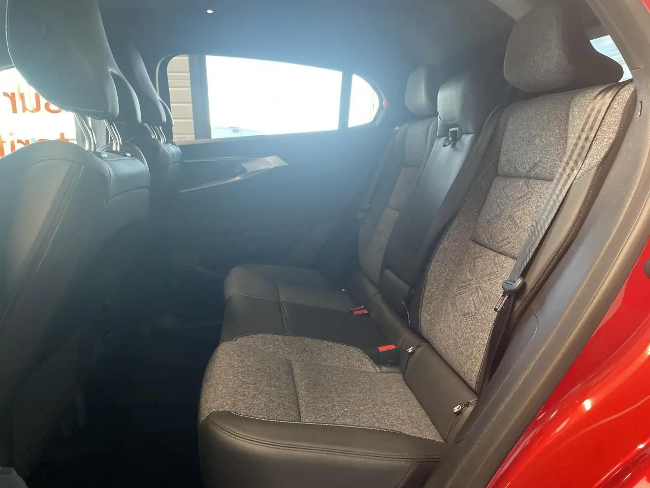 Vue côté droit de la banquette arrière mixte textile et cuir gris clair du Renault Rafale rouge 2025 avec porte ouverte.