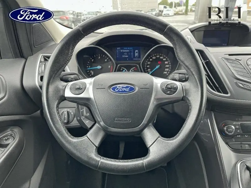 Vue rapprochée du volant cuir multifonction et du tableau de bord digital du Ford Kuga gris Magnetic 2015.