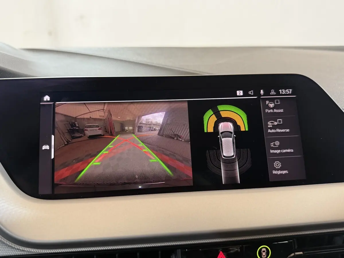 Écran tactile intérieur montrant la caméra de recul et l’aide au stationnement de la BMW Série 1 noire.