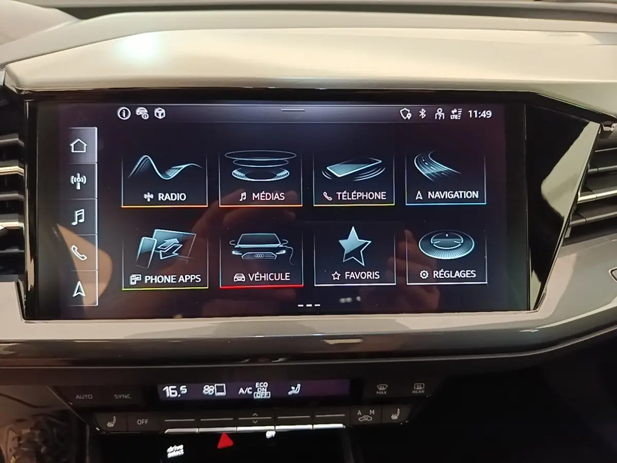 Écran tactile central de l’Audi Q4 E-Tron Sportback noir, affichant le menu multimédia et navigation.