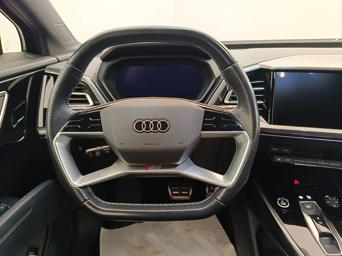 Vue frontale du volant cuir noir perforé et du tableau de bord digital de l'Audi Q4 E-TRON Sportback 2023.