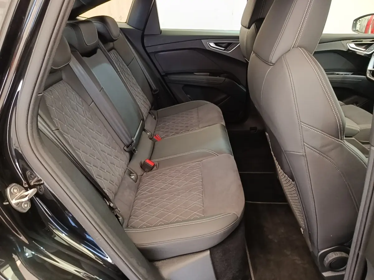 Vue intérieure côté gauche sur la banquette arrière en cuir noir matelassé de l'Audi Q4 E-Tron Sportback 2023.