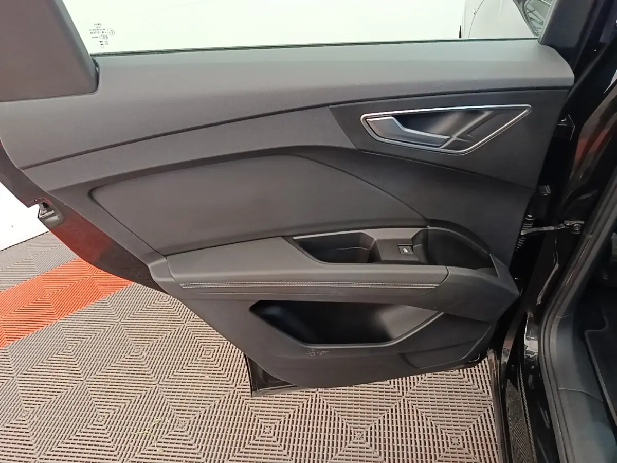 Gros plan sur la porte intérieure côté gauche noire de l’Audi Q4 E-Tron Sportback 2023 avec finition S Line.