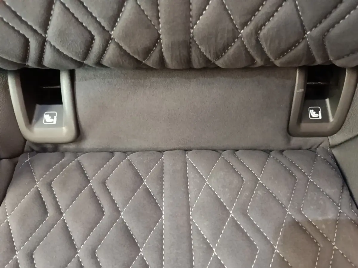 Détail des commandes de rabattement des sièges arrière sur tissu noir matelassé de l'Audi Q4 E-TRON Sportback.