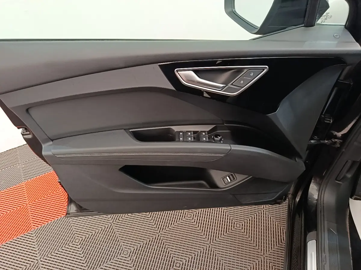 Vue intérieure de la porte côté conducteur de l'Audi Q4 E-TRON Sportback noire avec commandes de vitres et verrouillage.