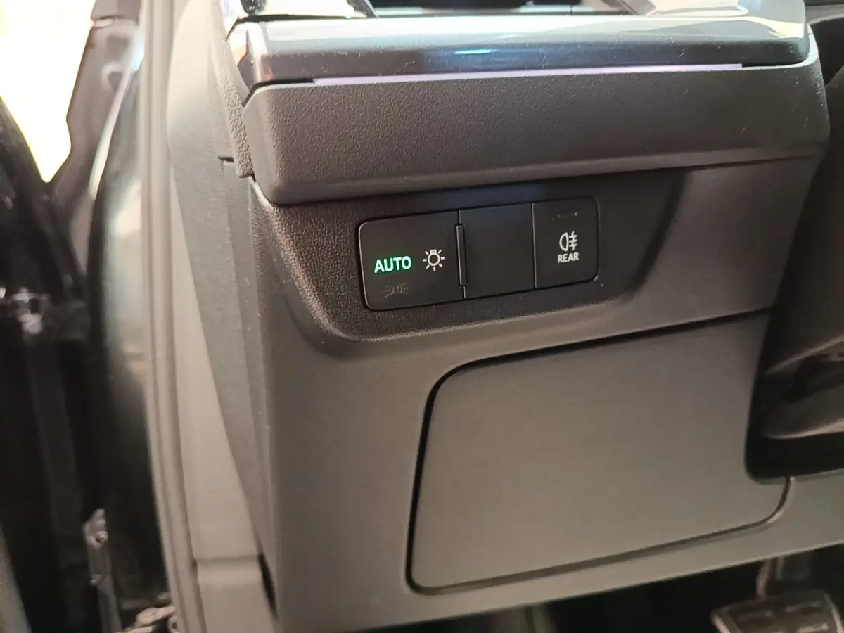 Détail des commandes d'éclairage avec bouton auto dans l'habitacle noir de l'Audi Q4 E-TRON Sportback 2023.