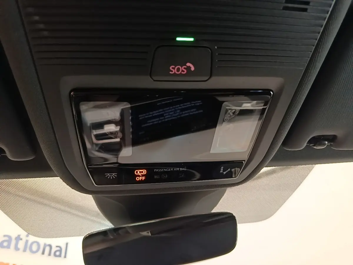 Vue rapprochée du plafonnier intérieur avec bouton SOS et indicateur airbag passager désactivé dans un Audi Q4 E-Tron Sportback noir.