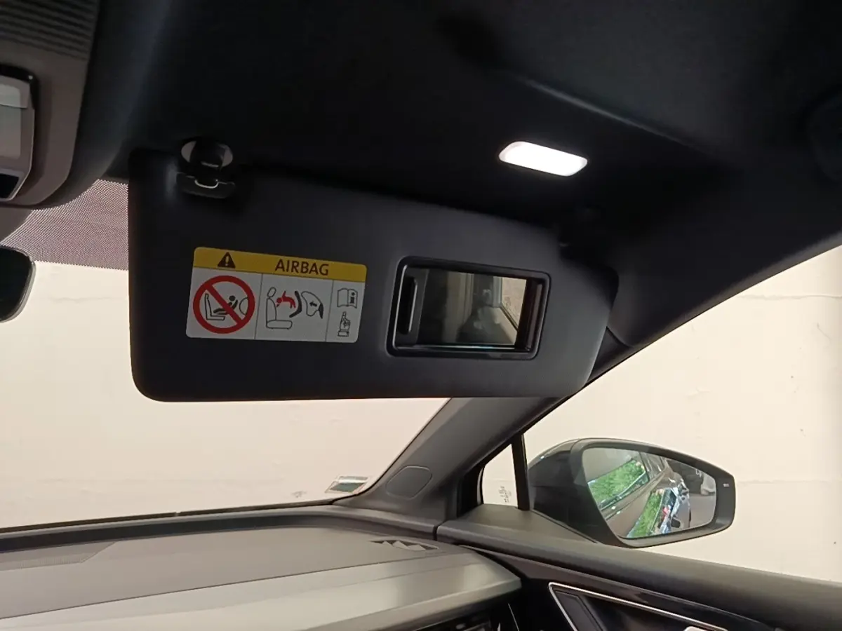 Intérieur Audi Q4 E-TRON Sportback 2023 noir, vue côté passager avec pare-soleil et rétroviseur extérieur visible.