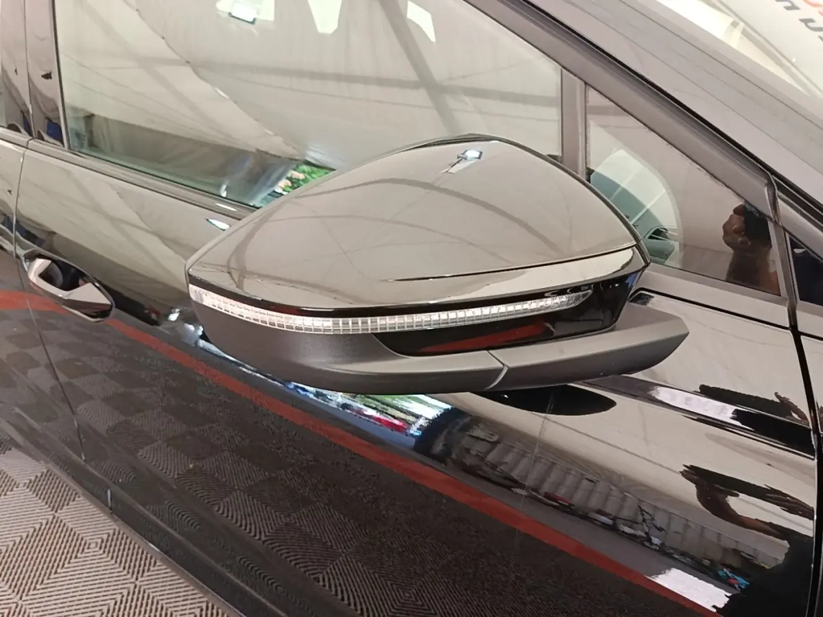 Rétroviseur droit noir brillant avec clignotant intégré sur Audi Q4 E-TRON Sportback noir, vue latérale rapprochée.