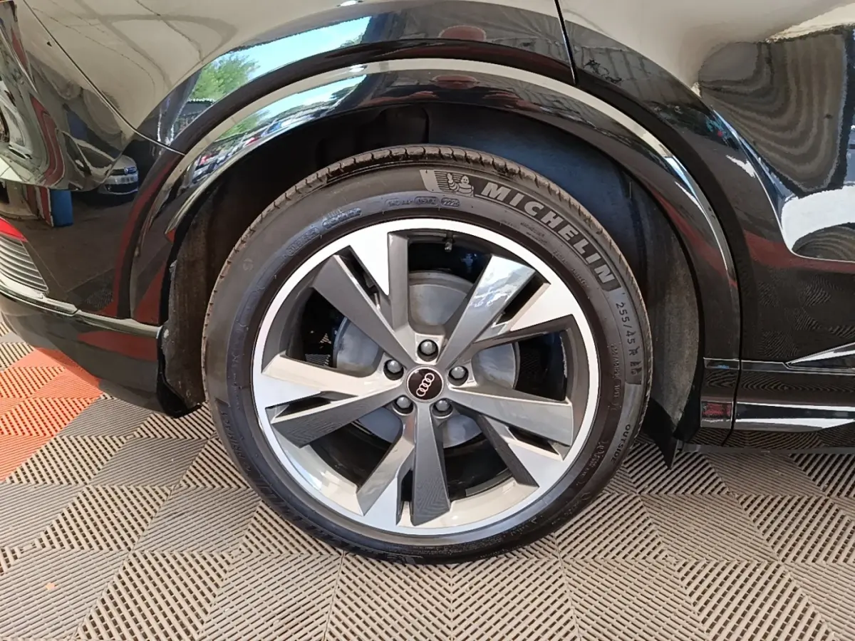 Gros plan sur la roue arrière droite noire d’un Audi Q4 E-TRON Sportback avec jante alliage et pneu Michelin.