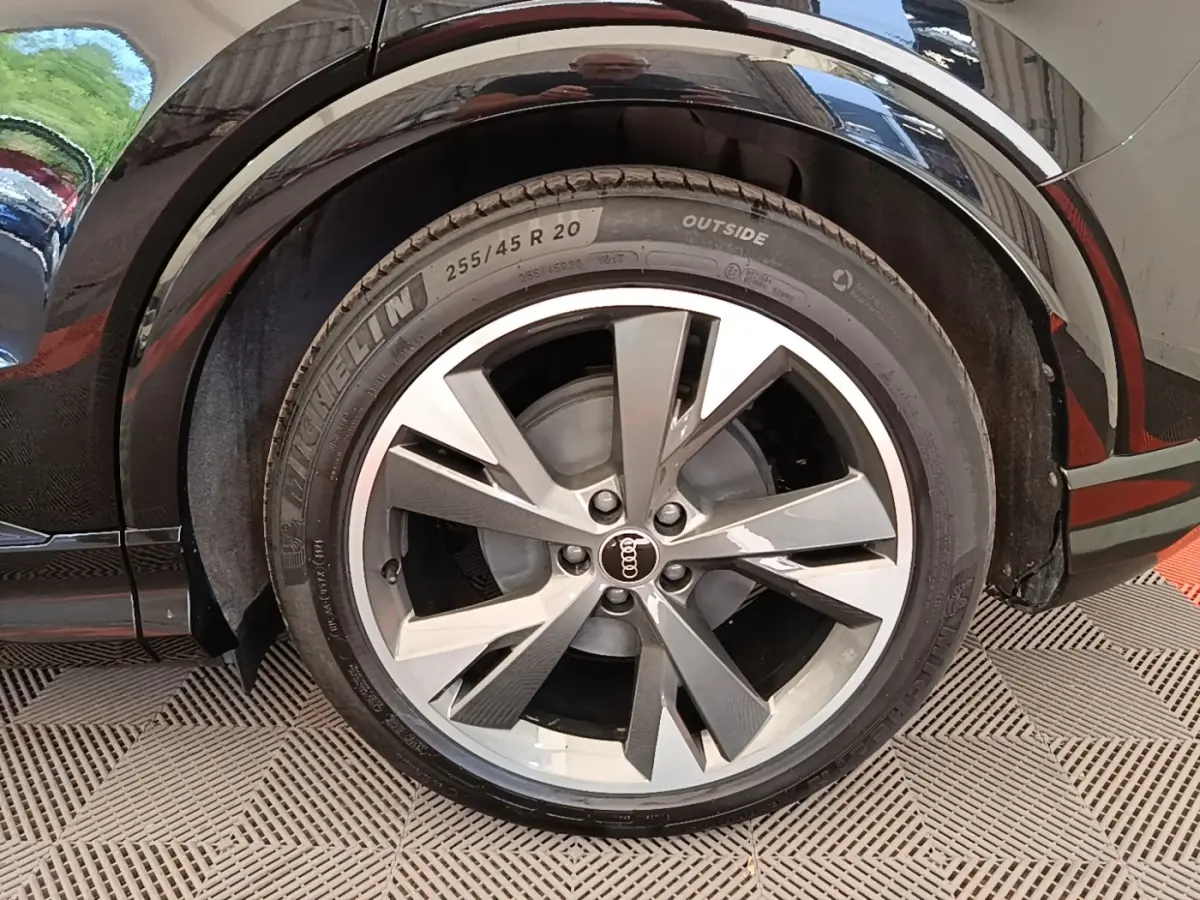 Gros plan sur la roue arrière droite noire d’un Audi Q4 E-TRON Sportback avec jante alliage à cinq branches doubles.