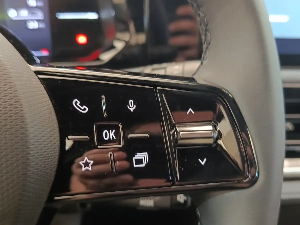 Gros plan sur les commandes multifonctions du volant côté gauche de la Renault Clio bleu évolution TCe 115 ch 2026.