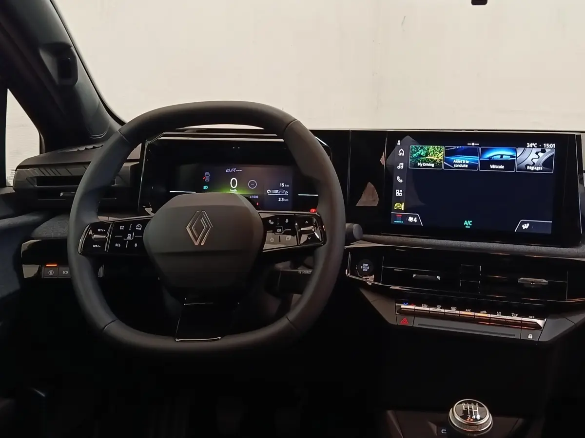 Intérieur de la Renault Clio 2026 vue du poste de conduite, volant multifonctions et grand écran tactile central.