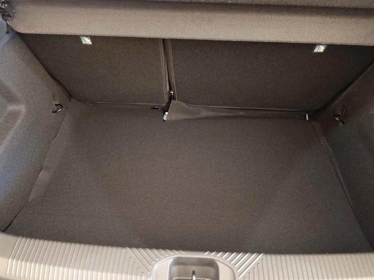 Coffre spacieux de Renault Clio Evolution TCe 115 2026, vue intérieure avec revêtement gris foncé.