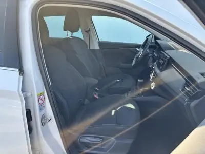 Intérieur avant droit d'une Skoda Scala blanc glacier 2024, sièges noirs et tableau de bord moderne visible.