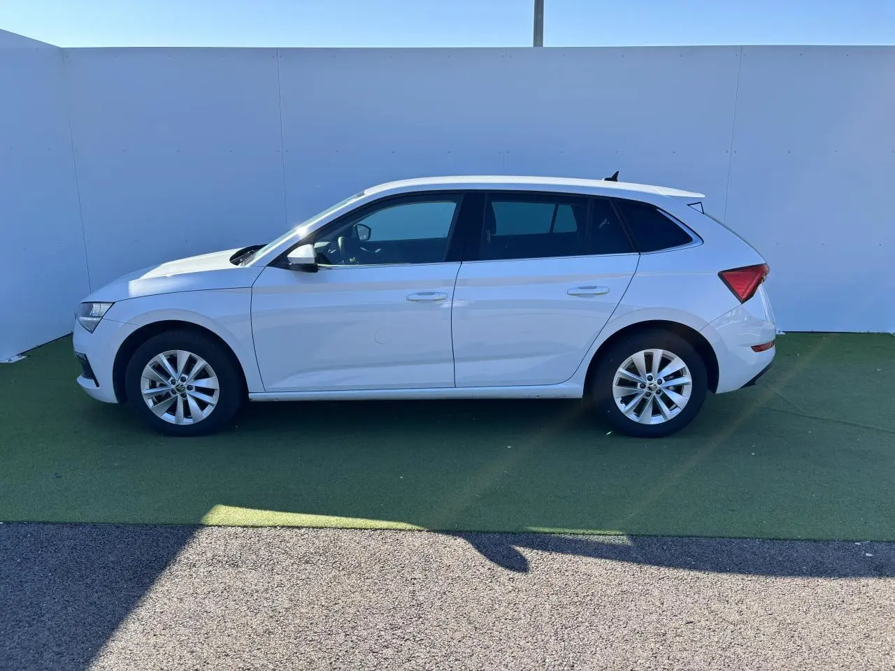 Profil latéral droit d'une Skoda Scala blanche glacier 2024 avec jantes alliage et vitres teintées.